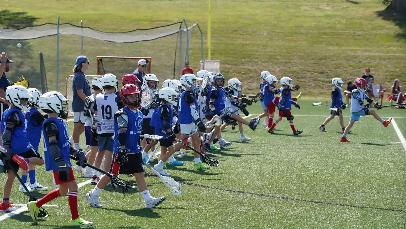 KC Elevate players in blue and white running a drill across a turf field