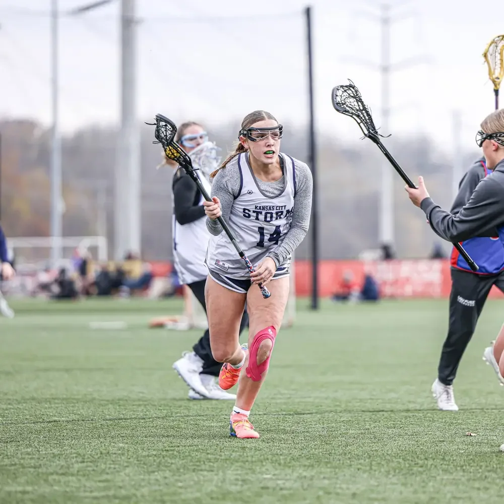 A KC Storm player cradling the ball upfield in a tournament game