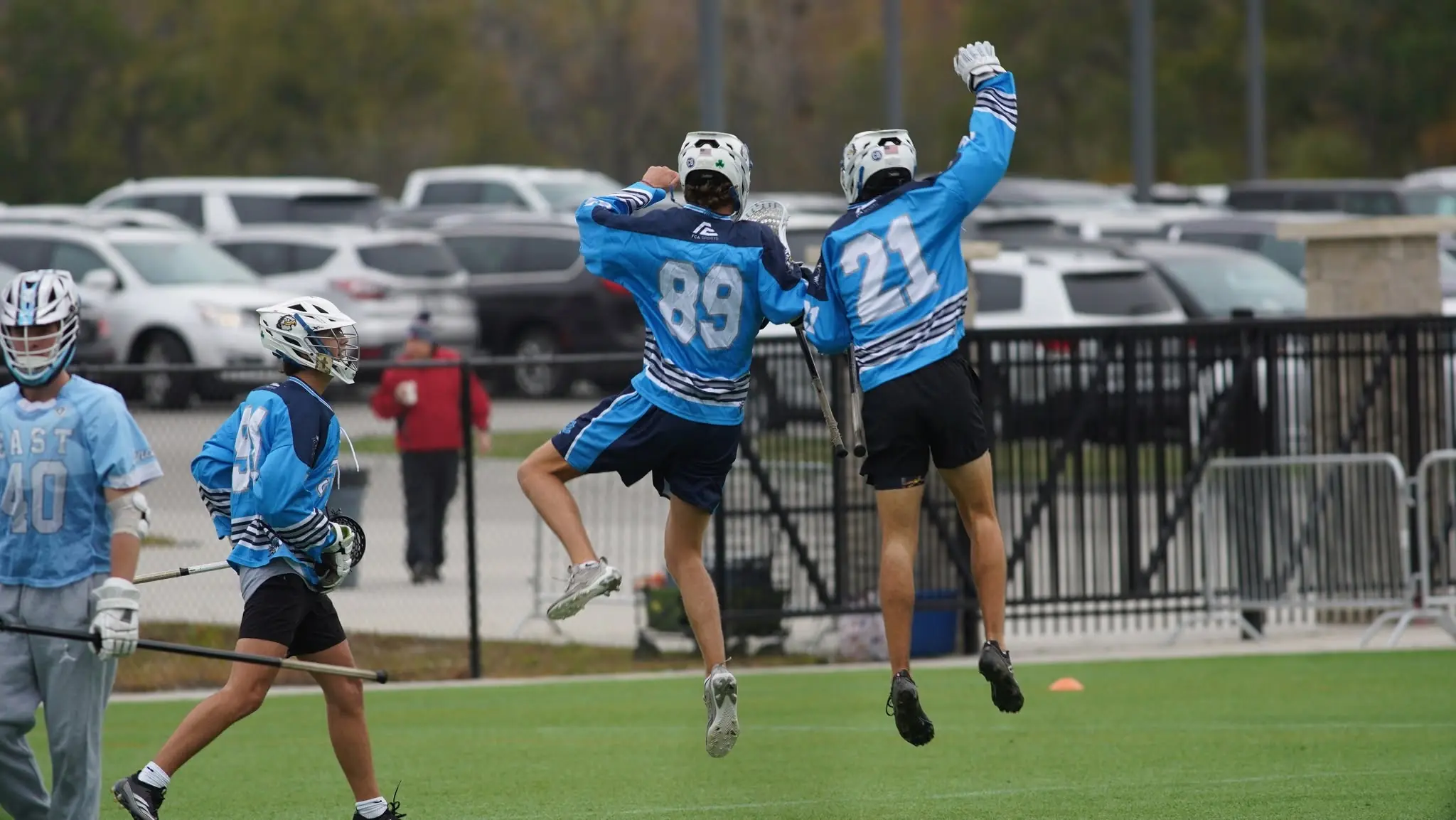 Two KC Elevate players, numbers 89 and 21, jumping to celebrate a goal
