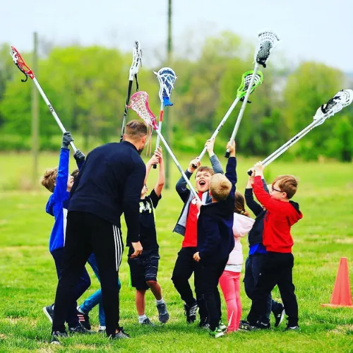 KC Elevate juniors raising their sticks with a coach