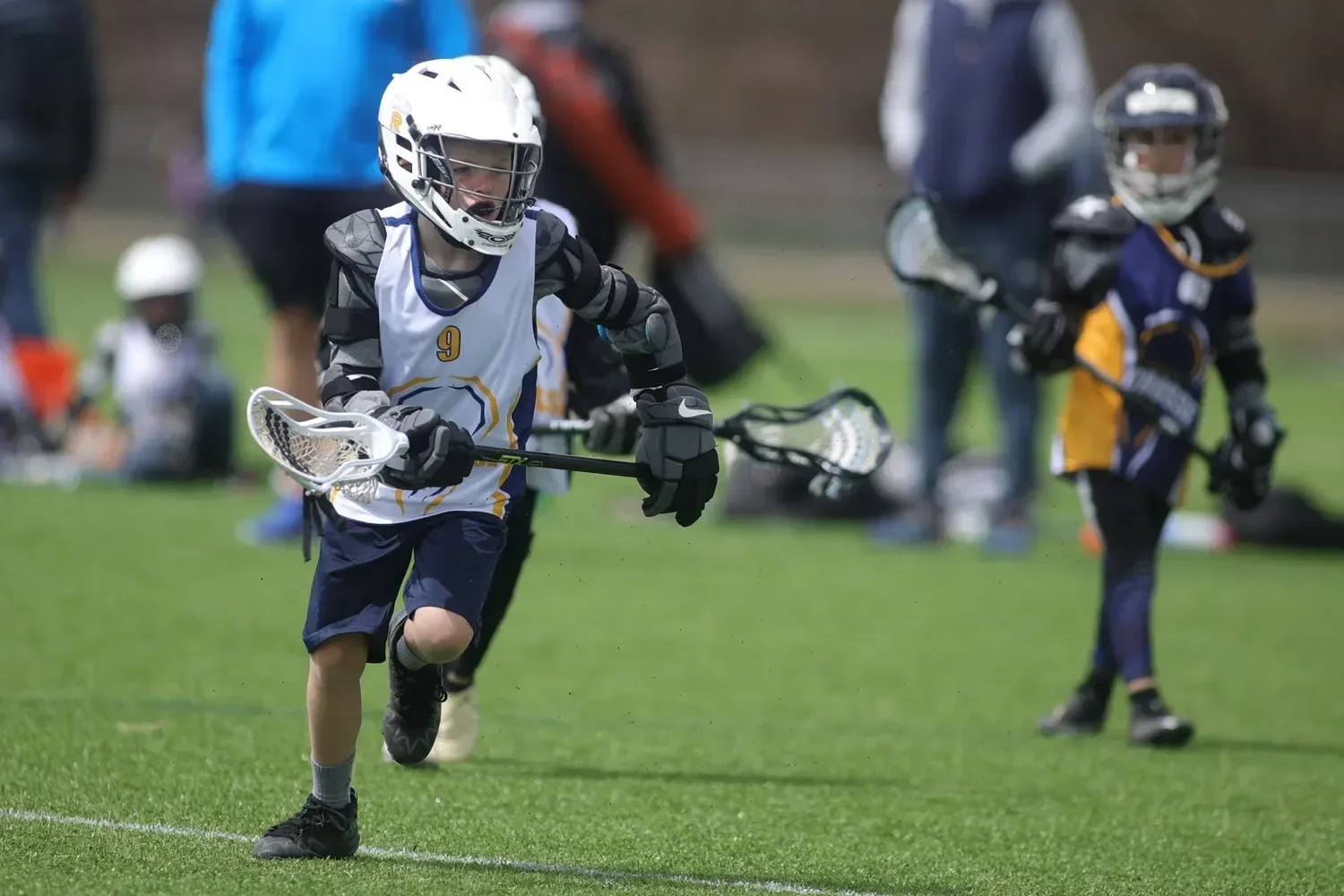 An Omaha Lacrosse Club player cradling the ball in a drill