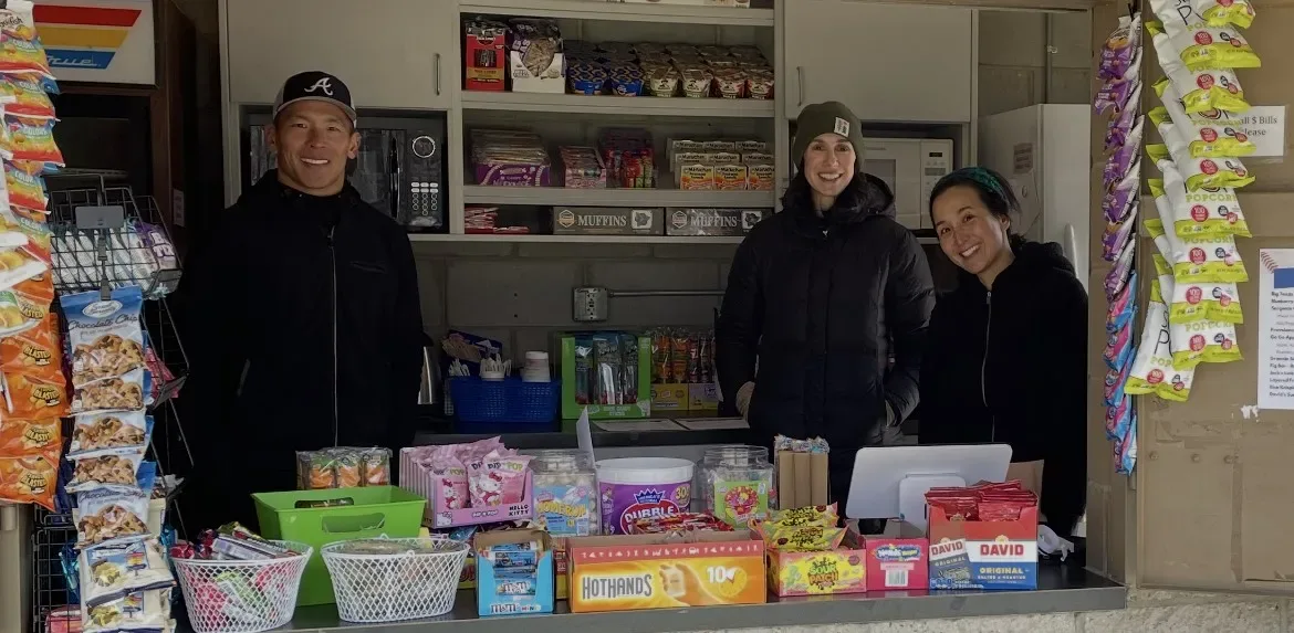 Three MBA volunteers in the Freeman Park concession stand